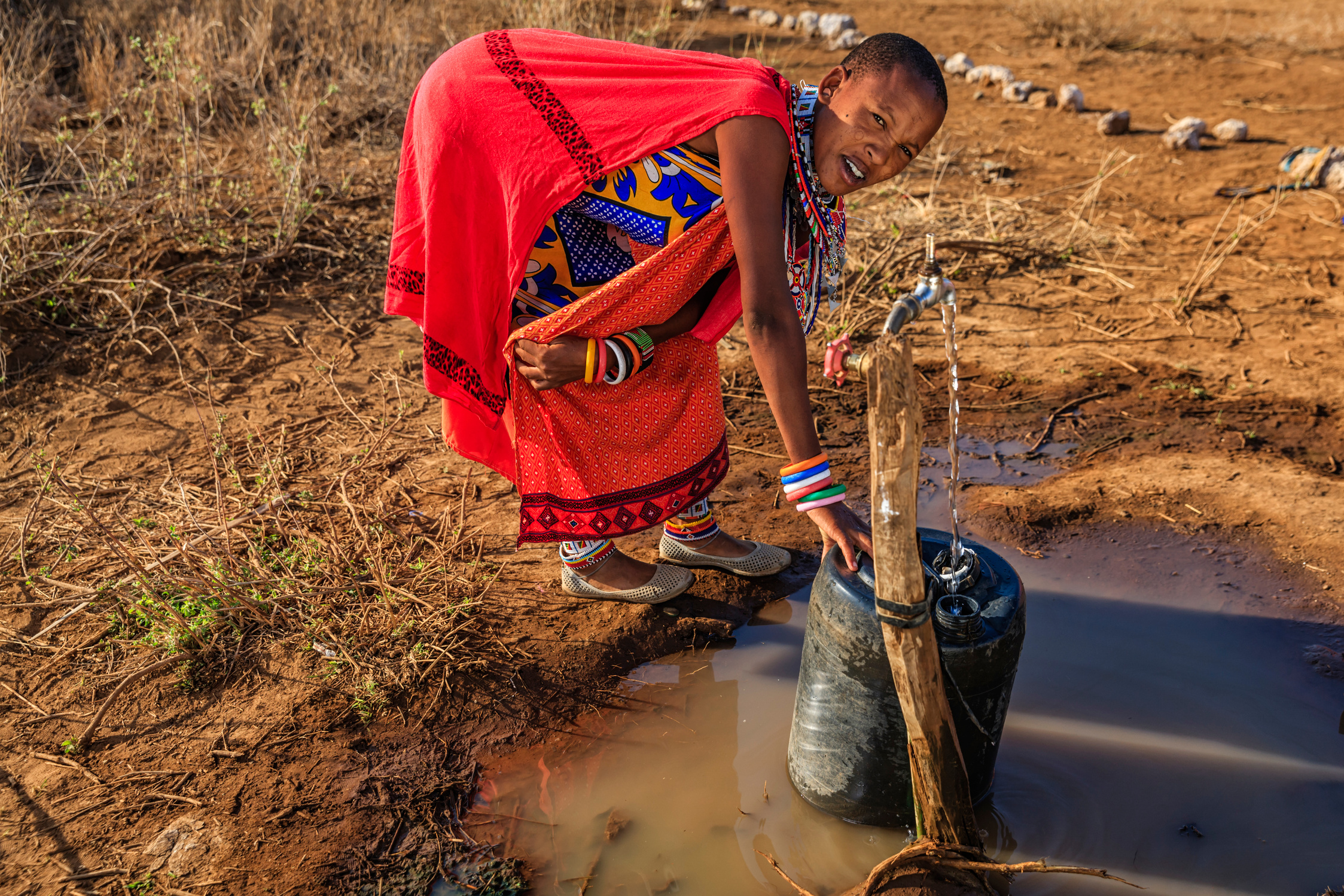 African woman from Maasai tribe collecting water, Kenya, East Africa